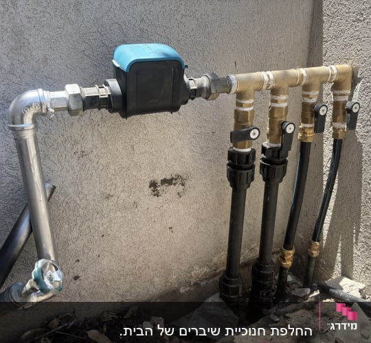 צנרת מים עם ברזים וחיבורים על קיר חיצוני